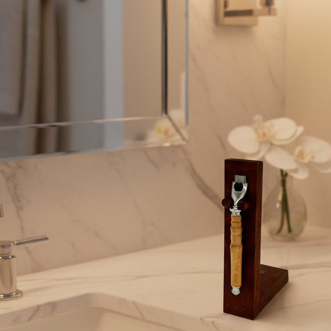 Wooden handle with metal component on a wooden block against a white background
